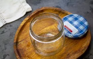 Kruopščiai išplaukite stiklainius su soda ir sterilizuokite juos jums patogiu būdu. Virkite dangtelius ant viryklės 10 minučių.