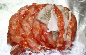 Surinkite „Armonikėlę“. Į kiekvieną įpjovimą įdėkite lašinių riekelę, krūtinėlę, vėl lašinių.