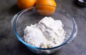 Į dubenį sudėkite varškę, grietinę ir cukrų.