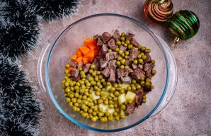 Į erdvų dubenį sudėkite bulvių, morkų, jautienos kubelius ir žirnelius.