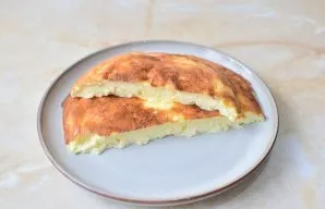 Perkelkite omletą į lėkštę ir patiekite. Pabarstykite smulkintais svogūnų laiškais.