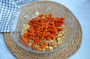 Džiovintus abrikosus nuplaukite karštu vandeniu arba nuplikykite verdančiu vandeniu, susmulkinkite ir sumaišykite su riešutais.