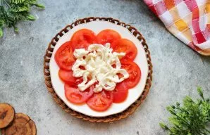 Ant pomidorų uždėkite stracciatella sūrio gijas, jas išlygindami.