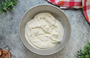 Dubenį su varškės mase uždenkite ir palikite kambario temperatūroje 25 minutes, kad manų kruopos sugertų drėgmę ir išbrinktų.