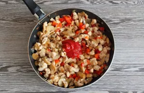 Įdėkite 1 šaukštą pomidorų pastos ir smulkintą česnaką. Gerai išmaišykite. Kaitinkite 3–4 minutes.