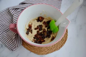 Silikonine mentele į tešlą įmaišykite smulkintas datules.