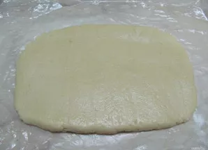 Kepimo popierių patepkite sviestu ir išdėkite vieną tešlos dalį. Galite iškočioti kočėlu arba formuoti rankomis. Tešlos formą priderinkit...