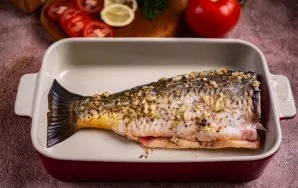 Paruoštą karpį dėkite į tinkamą indą. Aš naudojau keraminį kepimo indą. Užpilkite žuvį marinatu ir gerai įmasažuokite iš vidaus ir išorės...