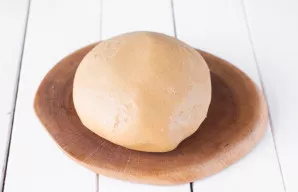 Išminkykite minkštą, elastingą tešlą, kuri šiek tiek limpa prie rankų. Apvyniokite tešlą maistine plėvele ir palikite ant stalo 20 minučių.