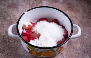 Imkitės uogų įdaro. Į puodelį sudėkite atitirpintas uogas, įberkite cukraus ir krakmolo.