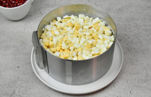 Paskutiniu sluoksniu išdėliokite smulkintus kiaušinius ir patepkite majonezu.