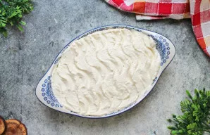 Kepimo formą patepkite sviestu ir pabarstykite manų kruopomis arba džiūvėsėliais. Į formą perkelkite varškės masę ir išlyginkite.