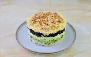 Pabarstykite graikiniais riešutais salotų viršų. Leiskite salotoms šiek tiek pasimarinuoti ir patiekite.